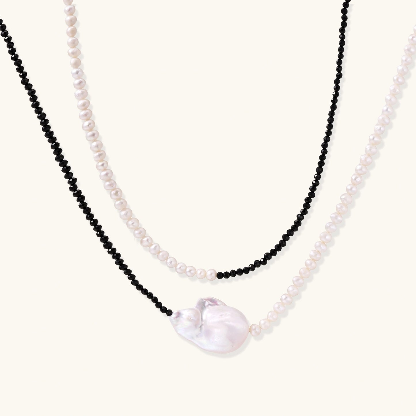 Double-strand necklace with black faceted quartz and white pearls featuring an oversized baroque pearl centerpiece